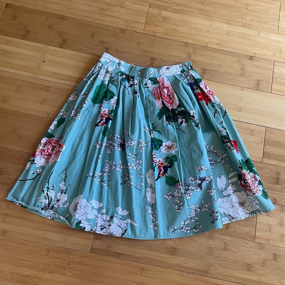 A line pleated skirt. Size Small. Green with flowers.